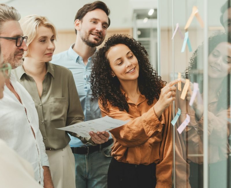 Scrum master talking with colleague using sticky notes, agile methodology.Teamwork, scrum